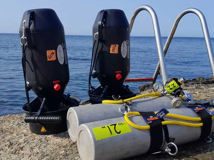 Bouteilles de plongée et détendeurs sur un quai rocheux ensoleillé