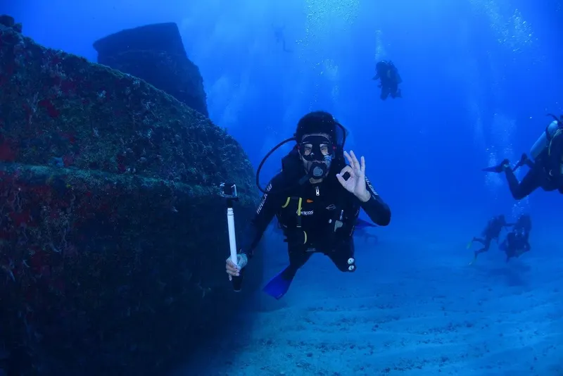 Plongeur souriant avec signe OK, exploration sous-marine en bleu profond
