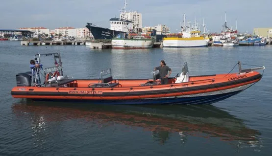 Bateau de plongée orange et bleu amarré dans un port ensoleillé