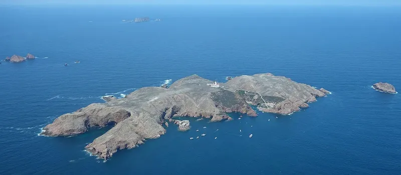 Vue aérienne d'une île rocheuse entourée d'une mer bleue calme