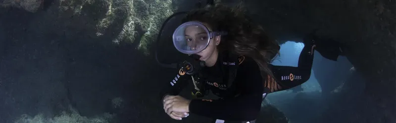 Plongeuse explore une grotte sous-marine avec son équipement complet