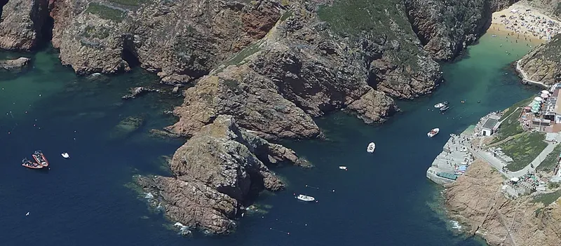 Côte rocheuse, bateaux en mer, parking et bâtiments du centre de plongée