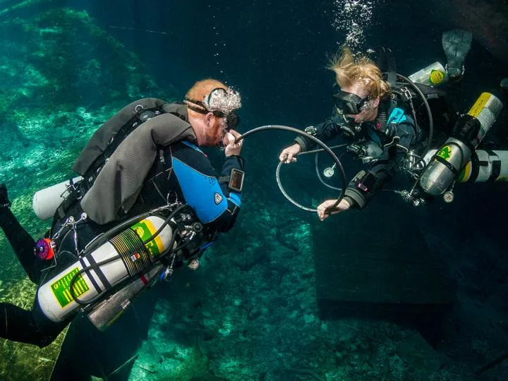 Deux plongeurs communiquent sous l'eau avec leur équipement complet