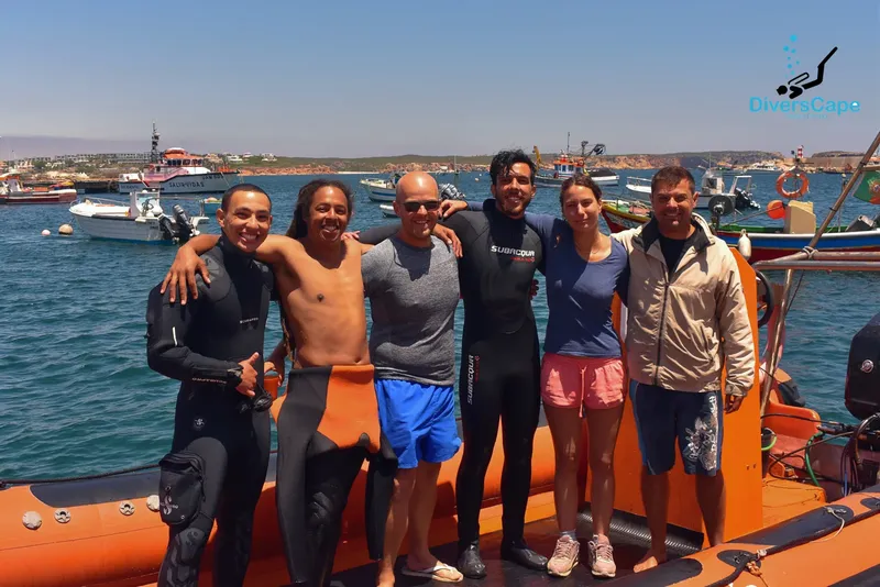 Groupe de plongeurs souriants sur un bateau orange en mer