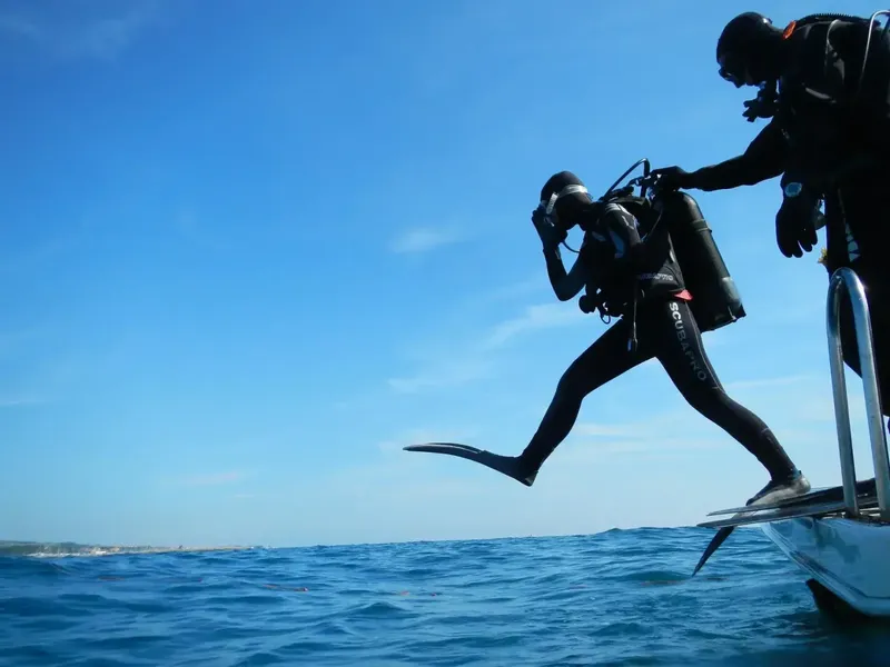 Plongeur s'apprête à sauter depuis un bateau en pleine mer