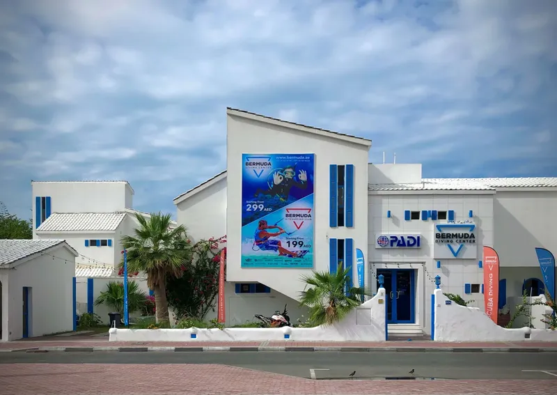 Bâtiment blanc avec affiches de plongée et logos de centres de plongée