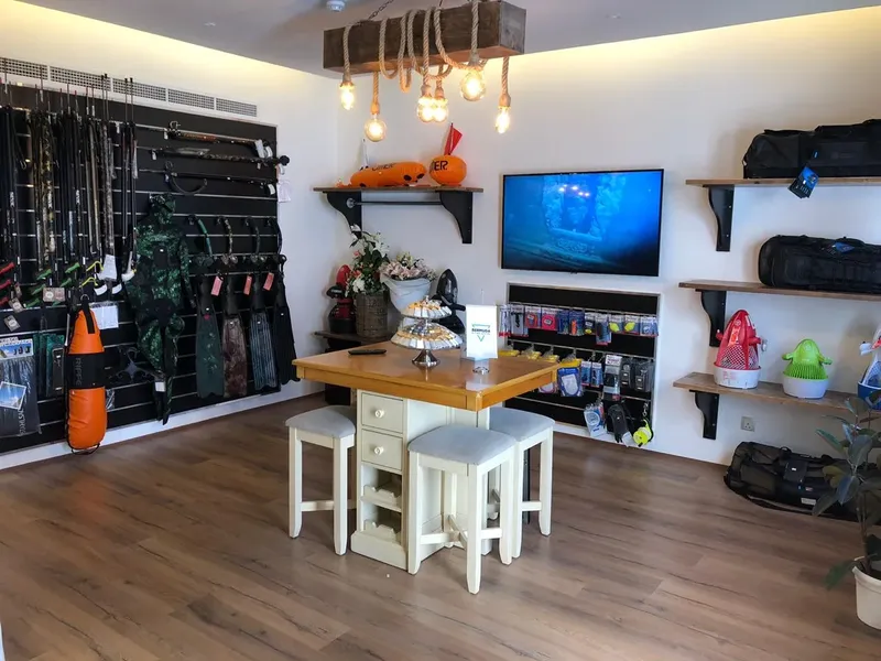 Intérieur d'un centre de plongée avec matériel, comptoir et écran vidéo