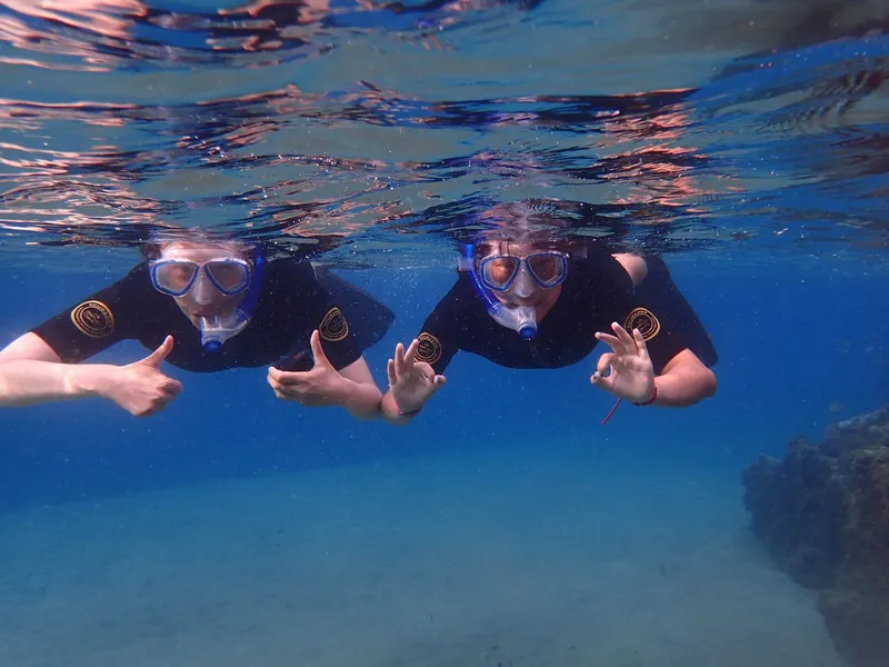 Deux plongeurs souriants avec des signes OK sous l'eau