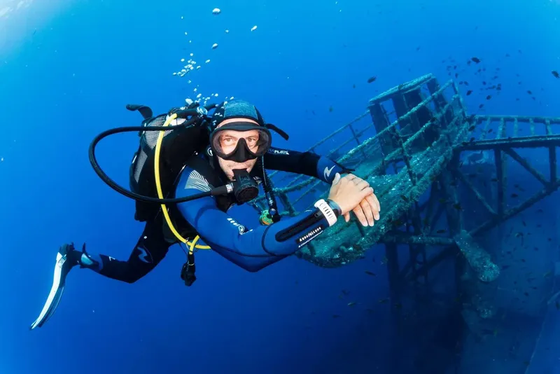 Plongeur en combinaison explore une structure métallique sous-marine