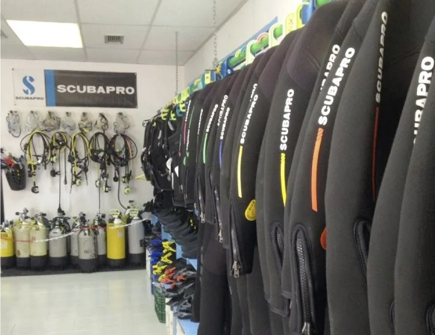 Rangées de combinaisons de plongée Scubapro et équipements dans un local