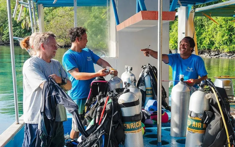 Personnes manipulant du matériel de plongée sur un bateau en mer