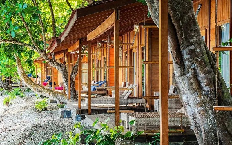Bâtiment en bois avec terrasses et transats au bord de l'eau