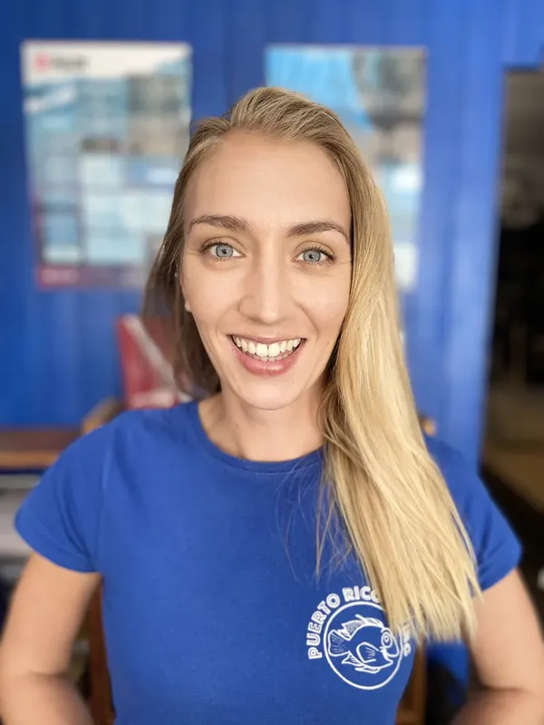 Femme souriante portant un t-shirt avec un motif de poisson tropical