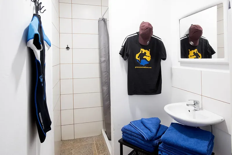 Vestiaire avec combinaison, t-shirt, serviettes et miroir dans un centre