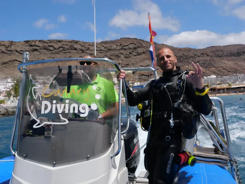Deux plongeurs souriants sur un bateau de plongée en mer