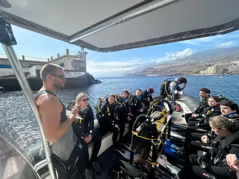 Groupe de plongeurs en combinaison sur un bateau semi-rigide en mer