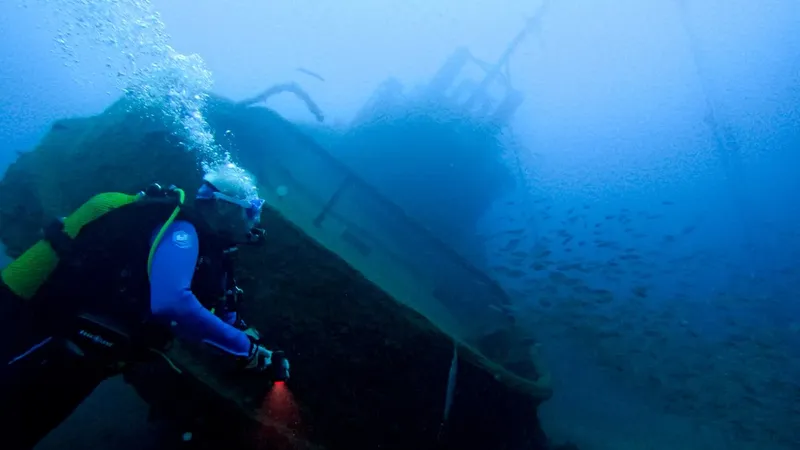 Plongeur explorant l'épave d'un navire sous l'eau, lumière bleutée