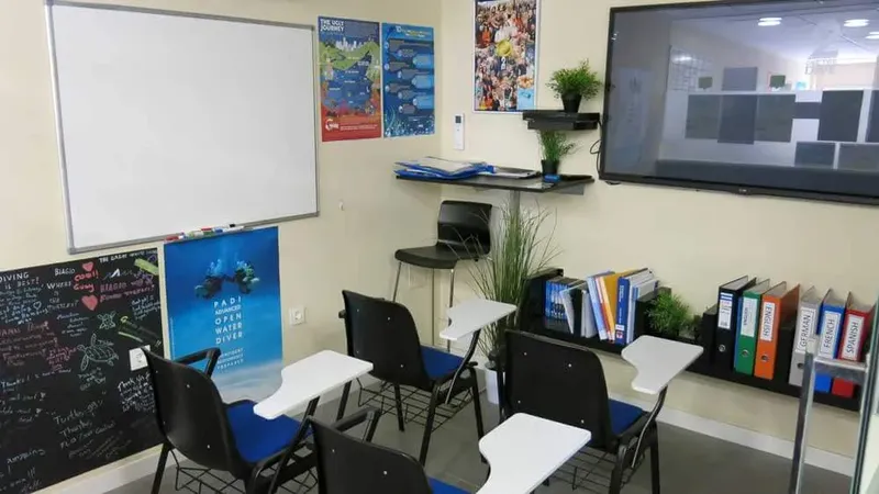 Salle de cours de plongée avec tableau blanc, chaises et étagères