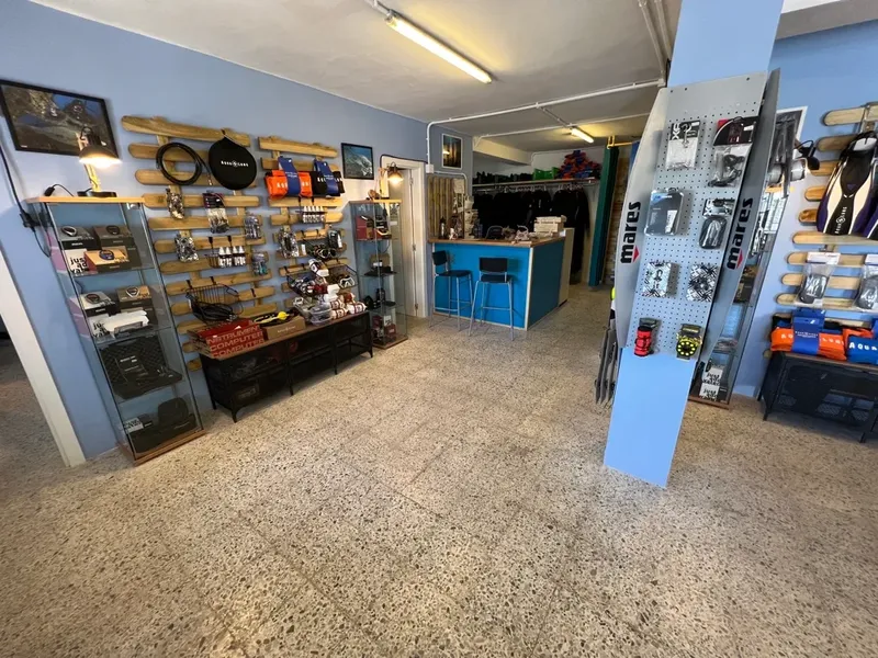 Boutique de plongée avec équipement exposé, comptoir d'accueil et rangement