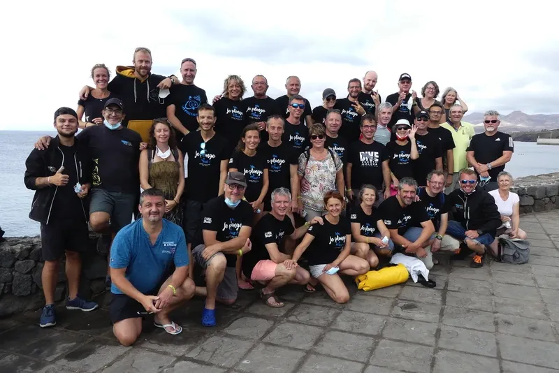 Groupe de personnes souriantes posant pour une photo en bord de mer