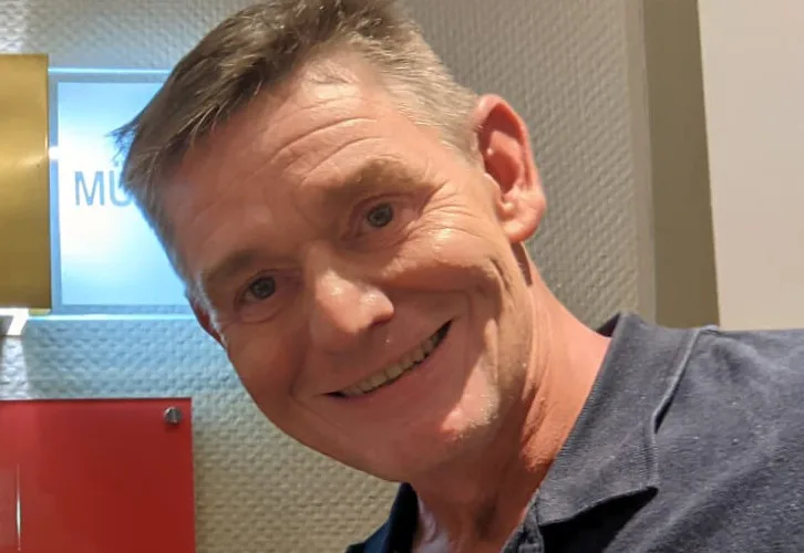 Portrait d'un homme souriant, regardant la caméra, intérieur clair