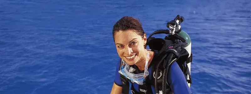 Plongeuse souriante avec son équipement complet en mer bleue