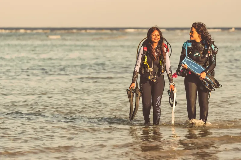 Deux plongeuses sortent de l'eau avec leur équipement complet