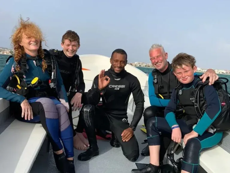 Groupe de plongeurs souriants à bord d'un bateau semi-rigide en mer