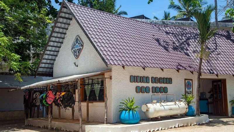 Façade d'une école de plongée avec équipement et végétation tropicale