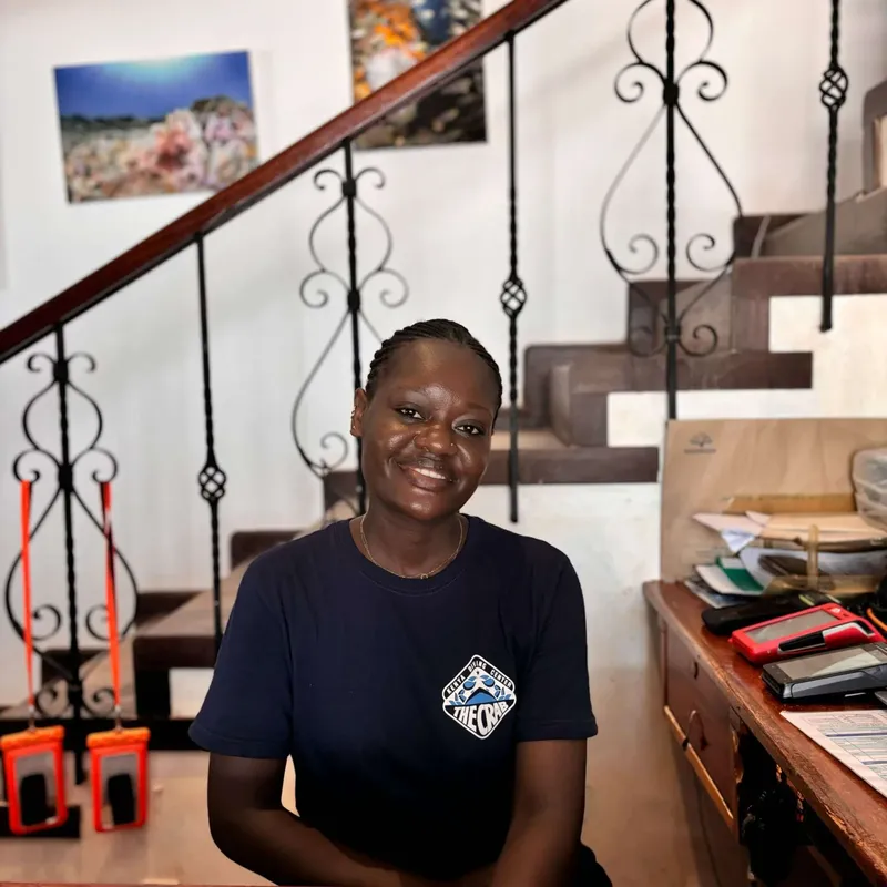 Femme souriante debout dans un intérieur avec un escalier décoratif