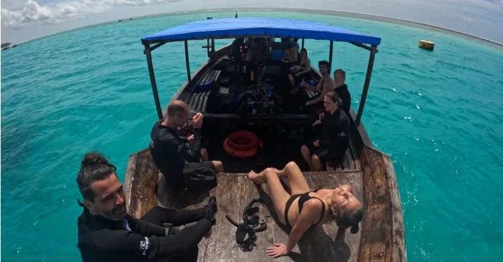 Plongée : groupe de personnes à bord d'un bateau en mer turquoise