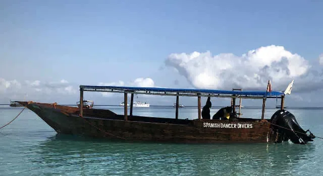 Bateau de plongée traditionnel amarré sur une mer turquoise et calme