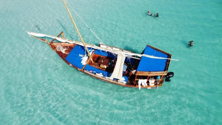 Vue aérienne d'un bateau traditionnel avec des personnes dans l'eau turquoise