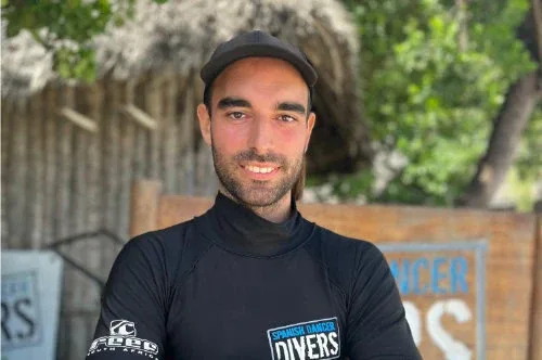 Portrait d'un homme souriant portant un rashguard noir et une casquette