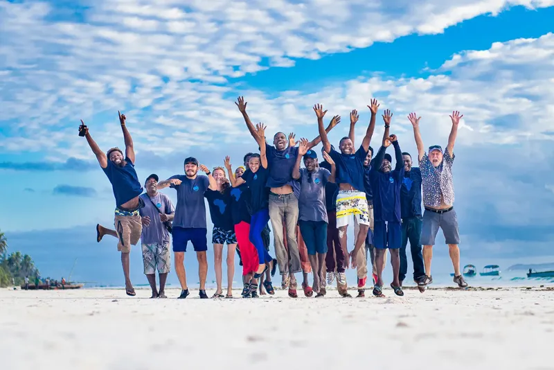 Groupe de personnes sautant sur une plage de sable blanc ensoleillée