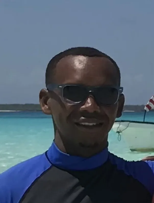 Homme souriant portant des lunettes de soleil sur un bateau en mer