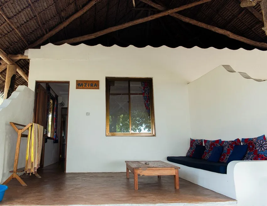 Espace détente intérieur avec canapé, table basse et fenêtre Mzira