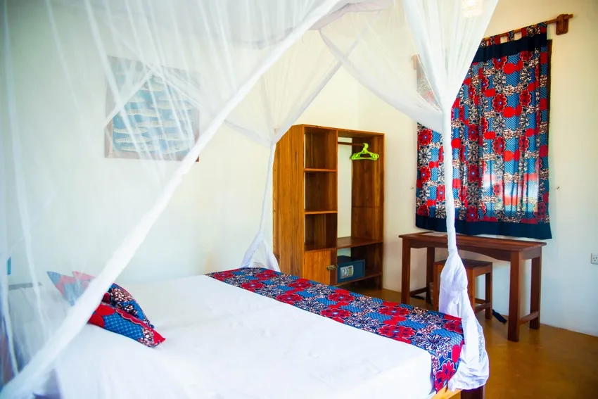 Chambre avec lit à baldaquin, meuble de rangement et décoration colorée