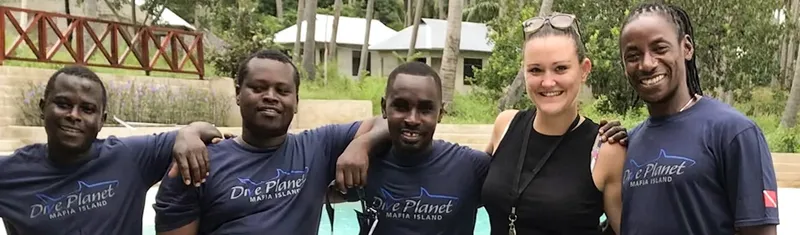 Groupe de personnes souriantes devant un bâtiment et des palmiers