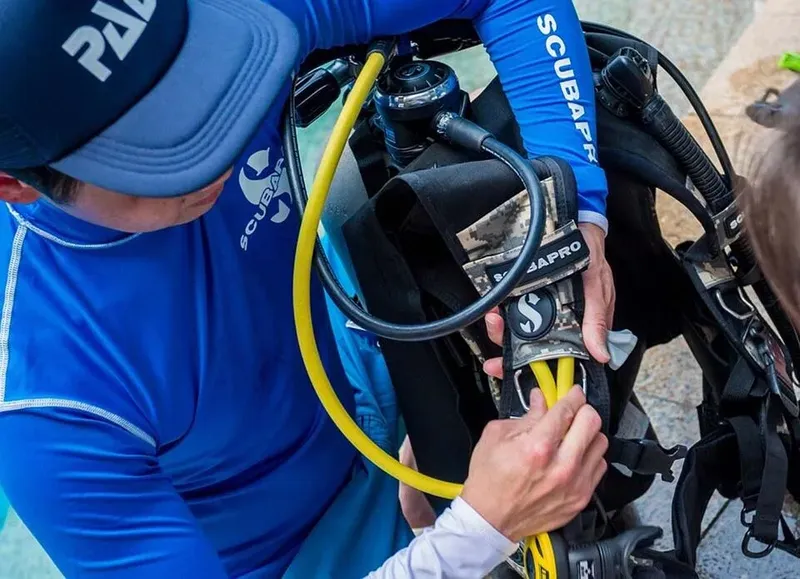 Plongeur vérifiant son équipement avant une immersion en mer