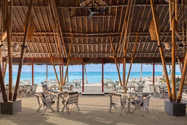 Terrasse de restaurant en bord de mer avec vue sur l'océan turquoise