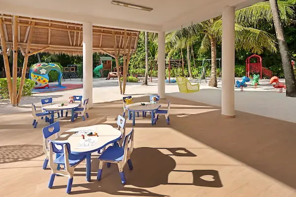 Aire de jeux pour enfants avec tables, chaises et structures colorées