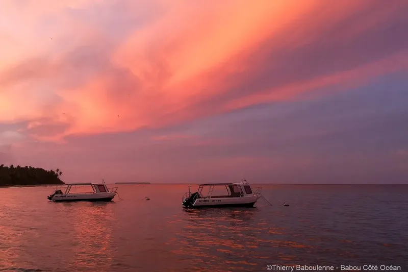 Deux bateaux de plongée amarrés au coucher du soleil sur l'océan
