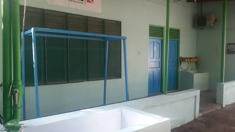 Facade d'un bâtiment avec des équipements de plongée et des bacs blancs
