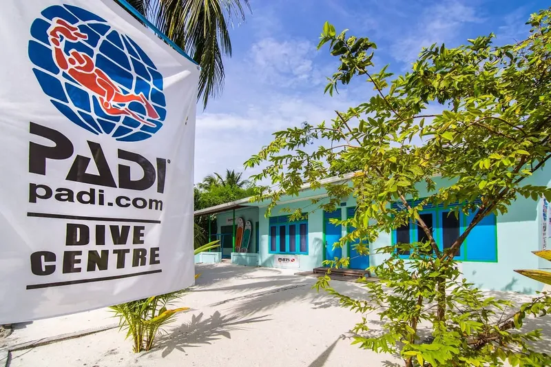 Façade d'un centre de plongée avec un grand drapeau PADI bleu