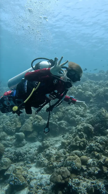 Plongeuse souriante fait le signe de la victoire sous l'eau