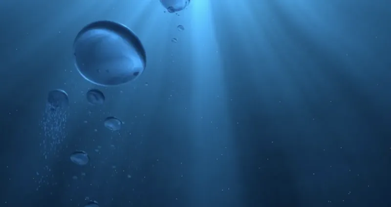 Bulles remontant dans l'eau bleue, rayons de lumière, ambiance marine