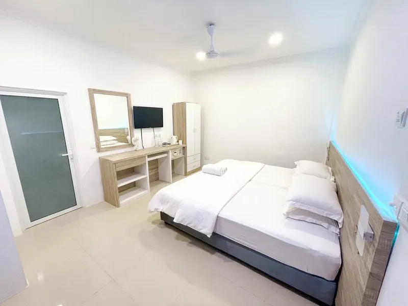Chambre d'hôtel lumineuse avec lit double, bureau et télévision
