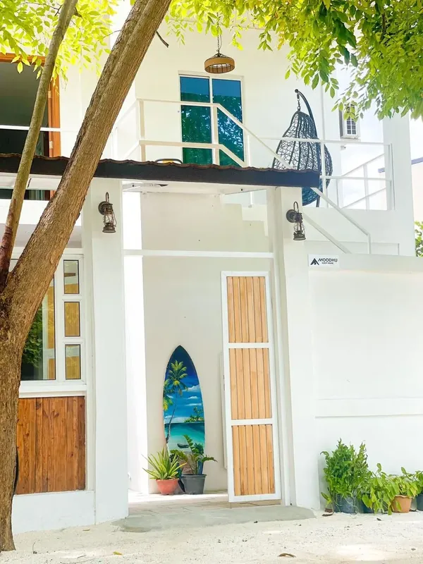 Façade d'un bâtiment blanc avec une planche de surf décorative
