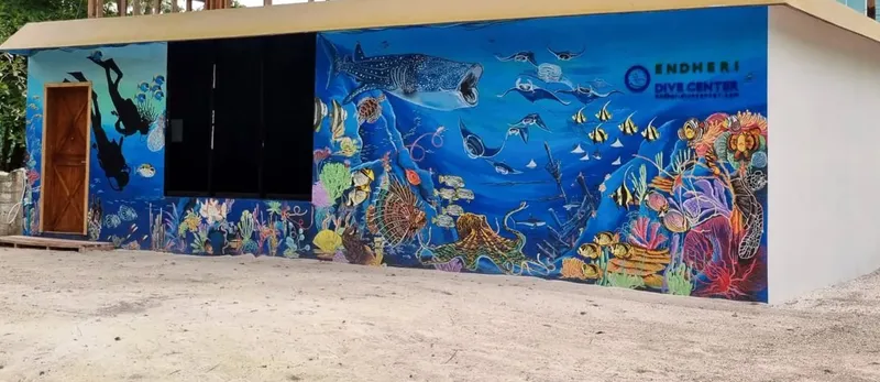 Mur peint d'un centre de plongée avec des plongeurs et des poissons